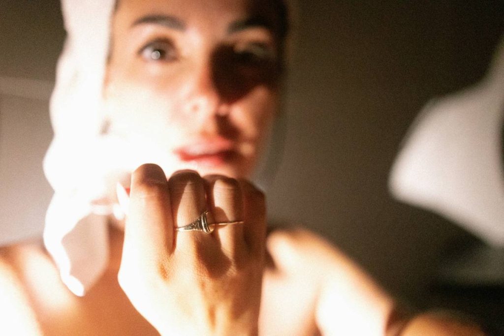 A woman is looking at her reflection in the mirror