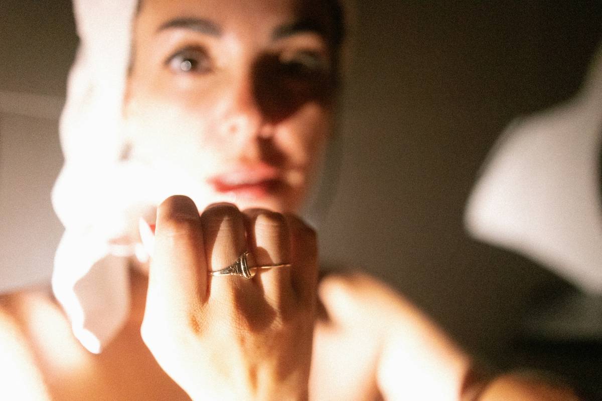 A woman is looking at her reflection in the mirror