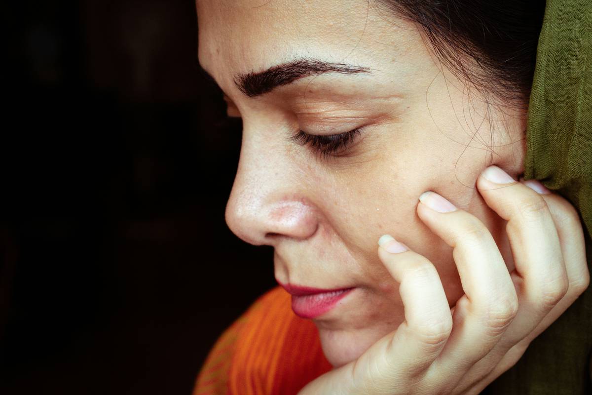 A woman's thoughtful profile in soft light